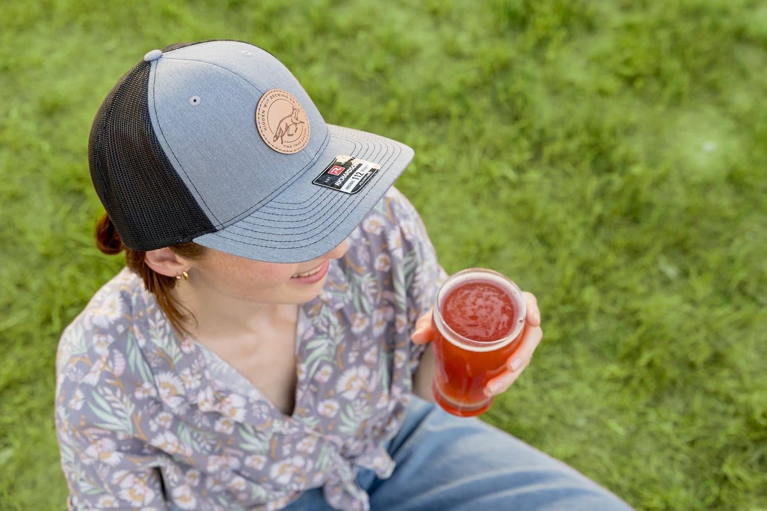 A guest enjoying a Hidden Wit beer on the lawn